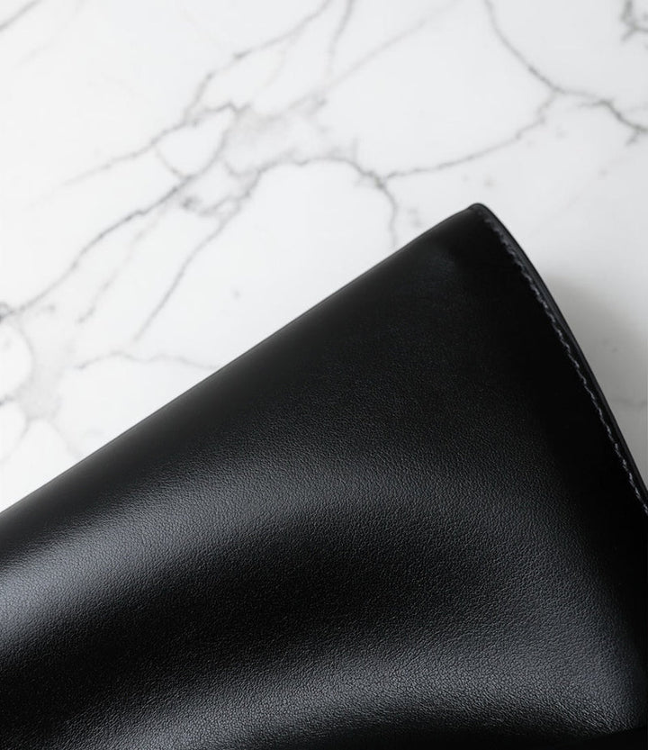 Black leather wallet on a marble surface