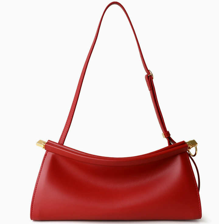 A red leather shoulder bag with a curved top, a single adjustable strap, and gold-tone hardware, shown against a plain white background.