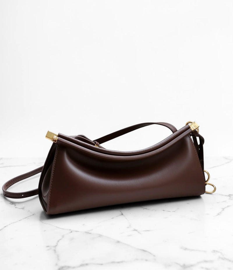 Brown handbag on a marble surface with a white background