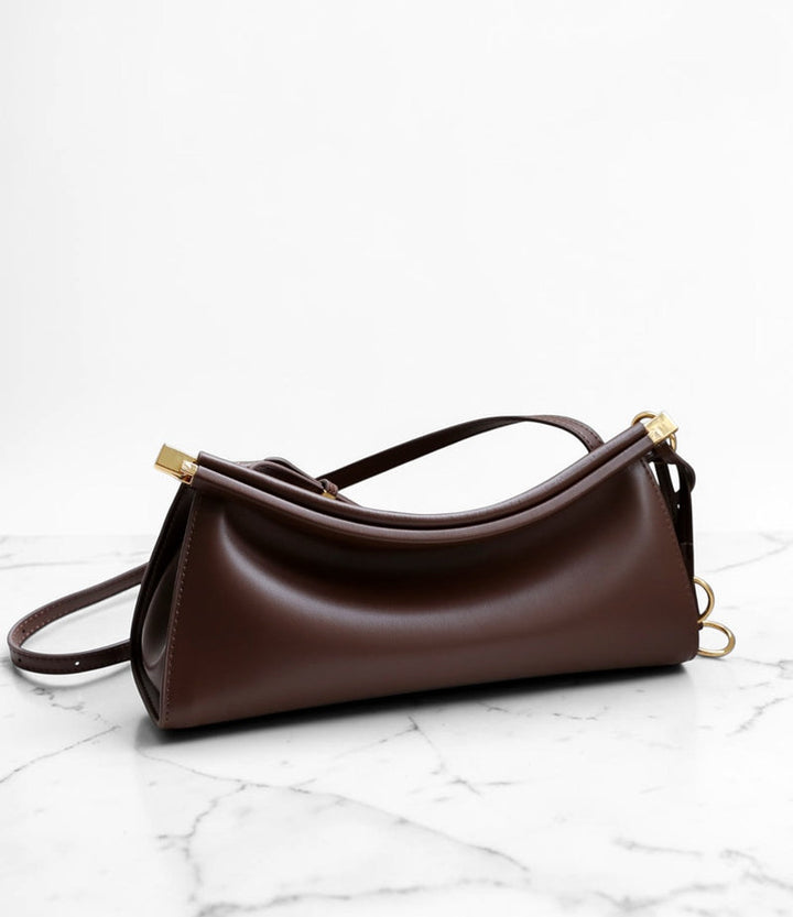 Brown handbag on a marble surface with a white background