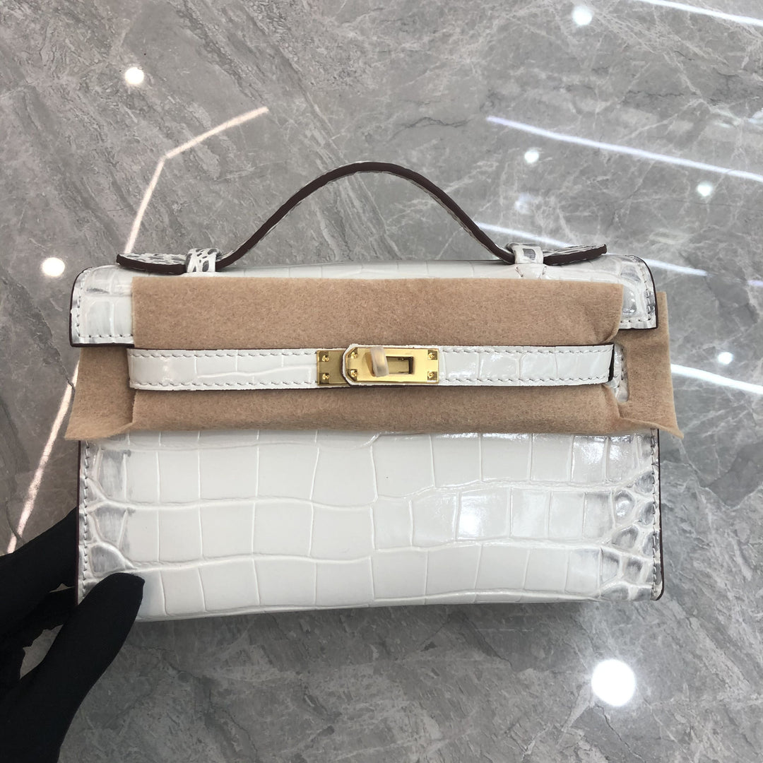 Designer handbag with gold clasp on a reflective surface