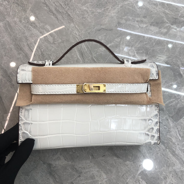 Designer handbag with gold clasp on a reflective surface
