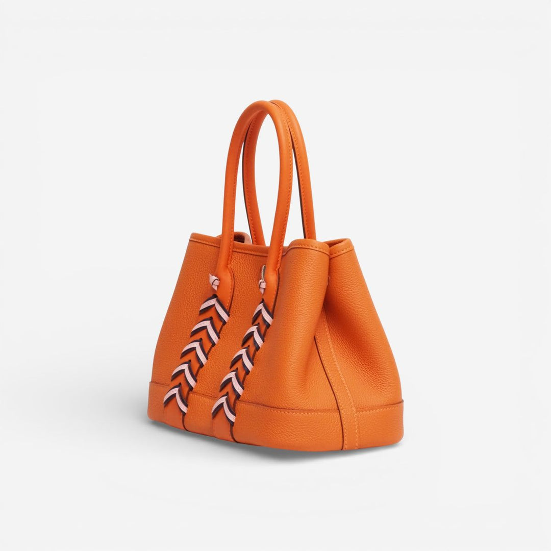 Luxury pebbled calfskin mini tote bag side view showing depth and handle drop