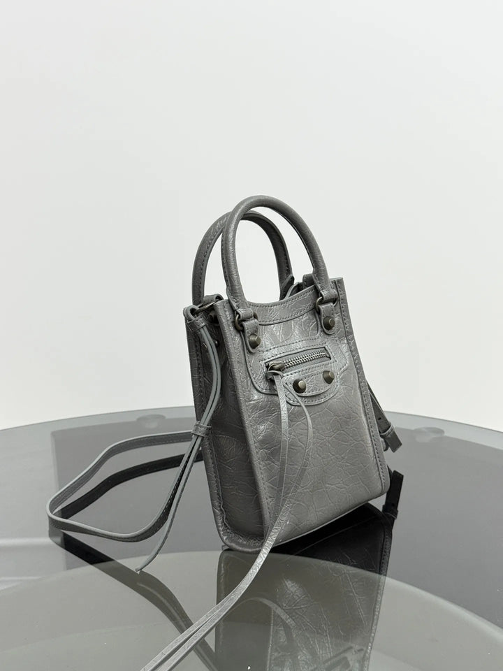 Mini tote crossbody bag front view showing rivet detailing and vertical structured silhouette