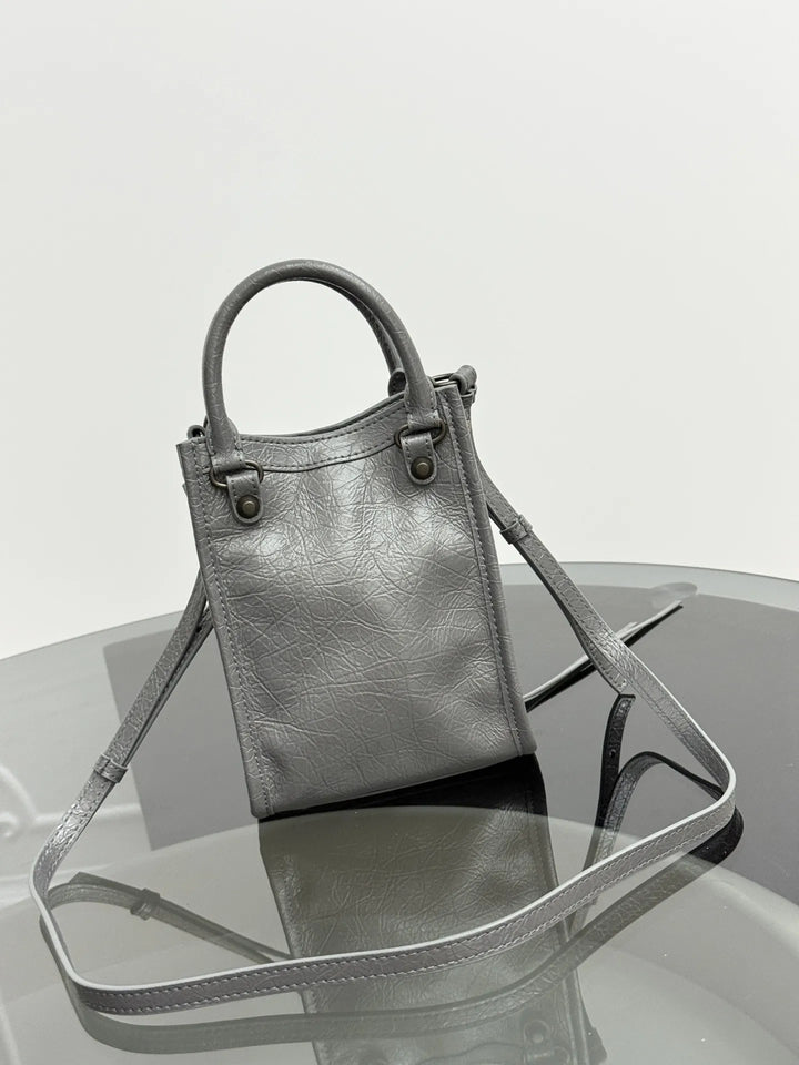 Namrico crinkled leather mini tote close-up of rivet and fringe embellishment detail