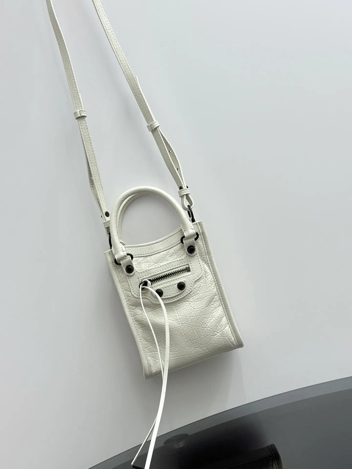 Black crinkled leather mini tote bag lifestyle shot carried crossbody on shoulder