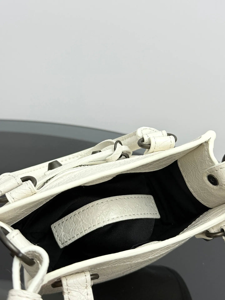 Silver leather mini tote bag angle view highlighting rivet stud arrangement and fringe detail