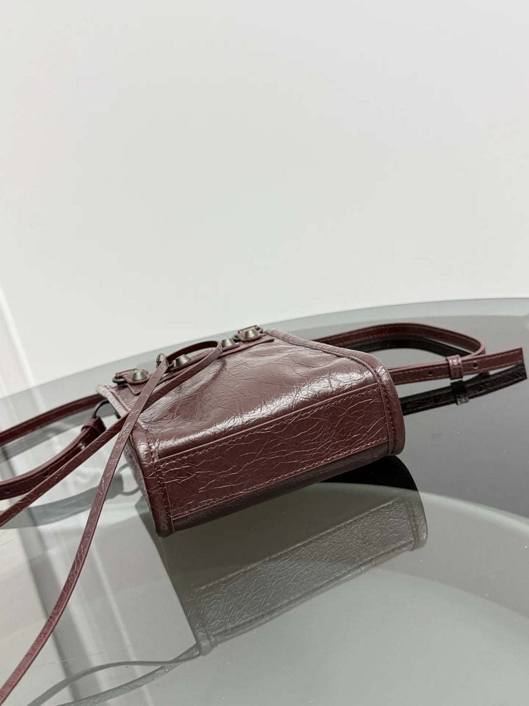 Gray leather rivet fringe mini tote crossbody bag lifestyle shot at street style setting