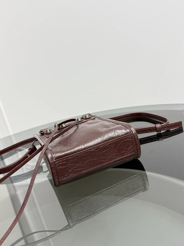 Gray leather rivet fringe mini tote crossbody bag lifestyle shot at street style setting