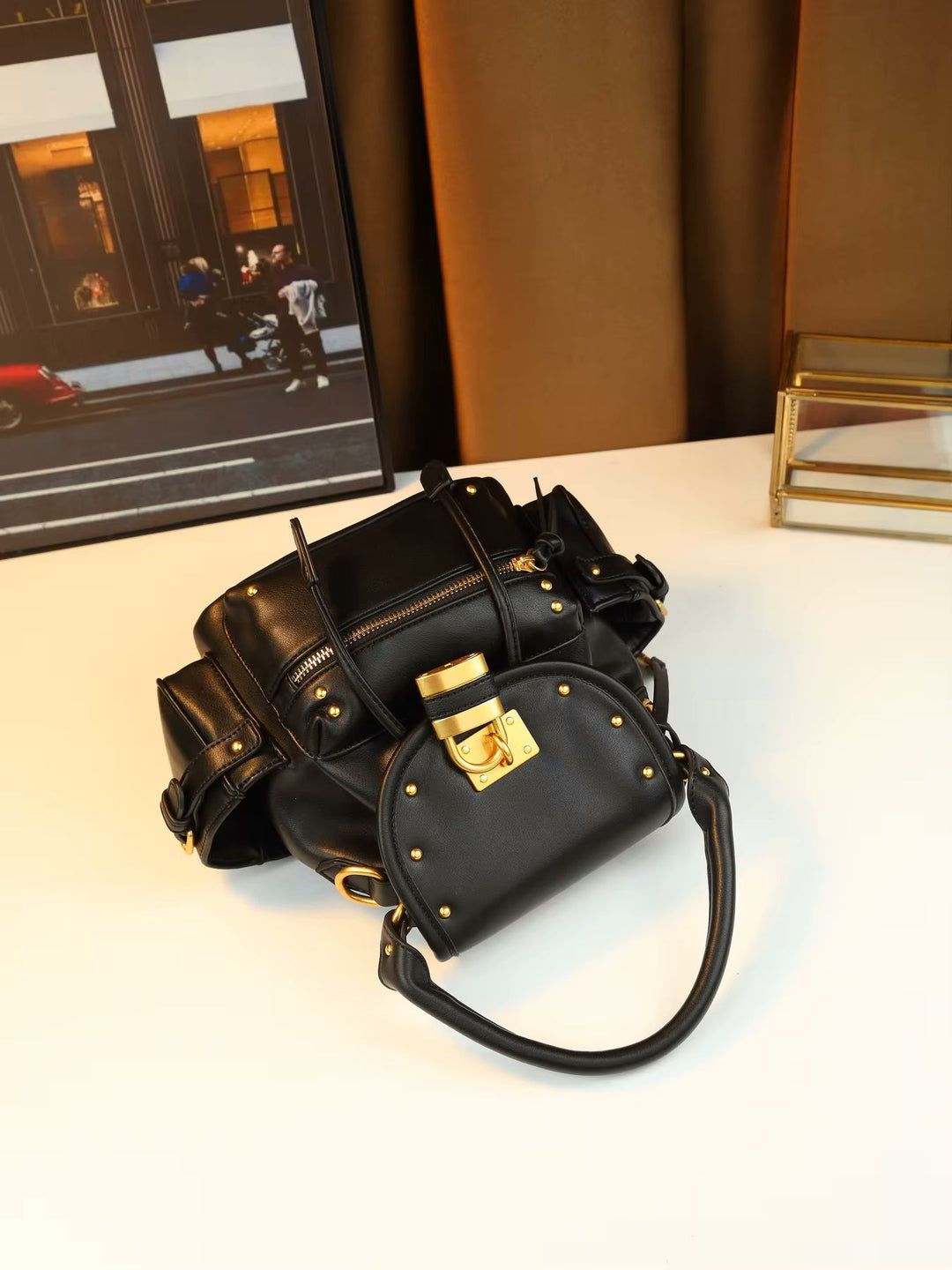 Namrico padlock flap bag lifestyle shot carried in hand at outdoor minimalist setting
