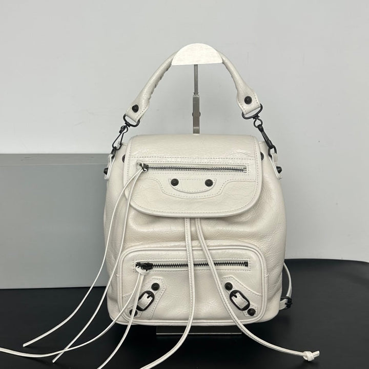 Pink leather studded flap backpack lifestyle shot on minimalist studio stand