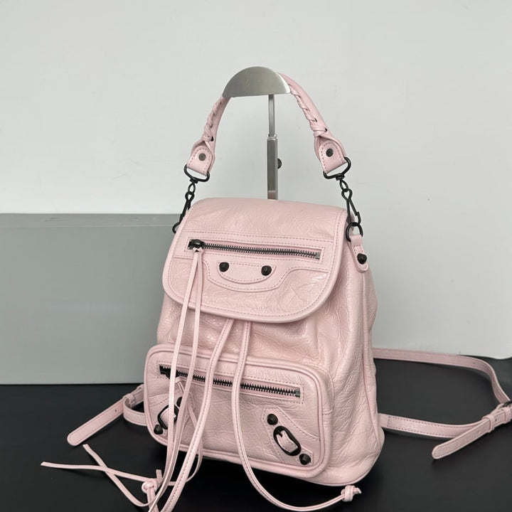 white leather biker style backpack close-up of black stud detailing and drawstring tabs