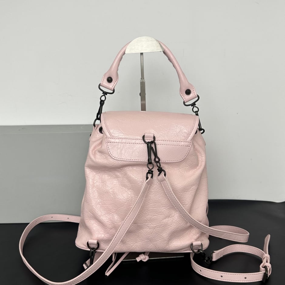white leather biker style backpack close-up of black stud detailing and drawstring tabs Namrico