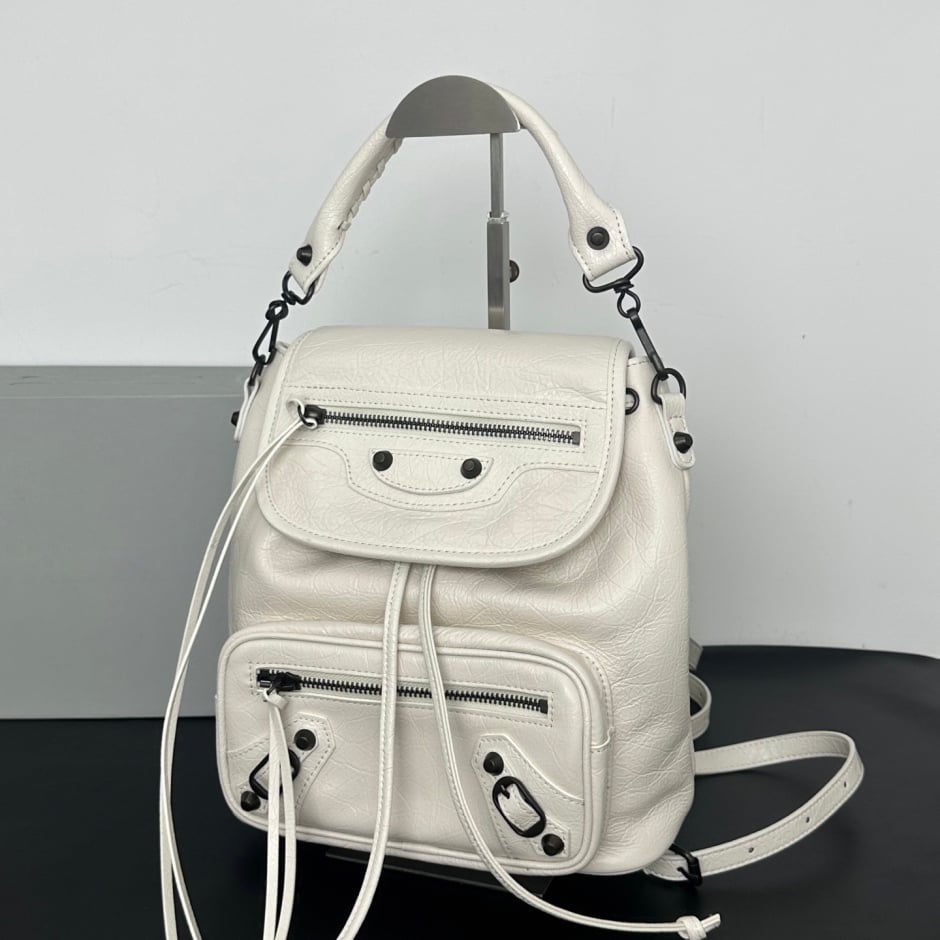 A dark brown pebbled leather backpack with multiple zippered pockets and a top handle, displayed on a stand against a white 