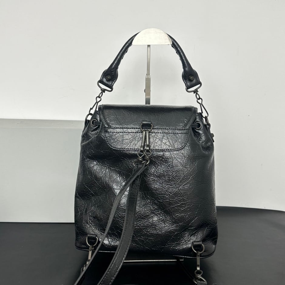 Brown leather biker style flap backpack angle view showing full stud arrangement