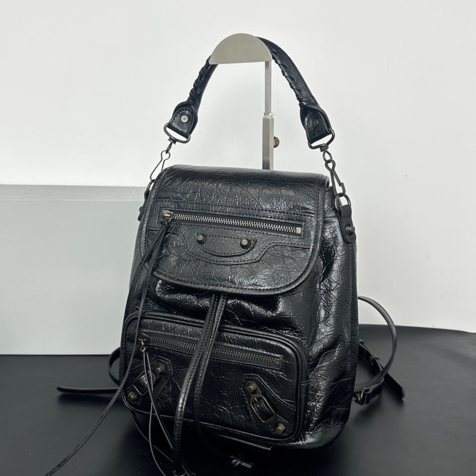 Namrico studded leather backpack top view showing flap hasp closure and top handle hardware
