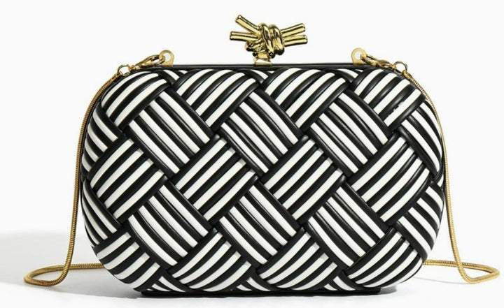 White and gold woven clutch bag angle view highlighting structured oval shape
