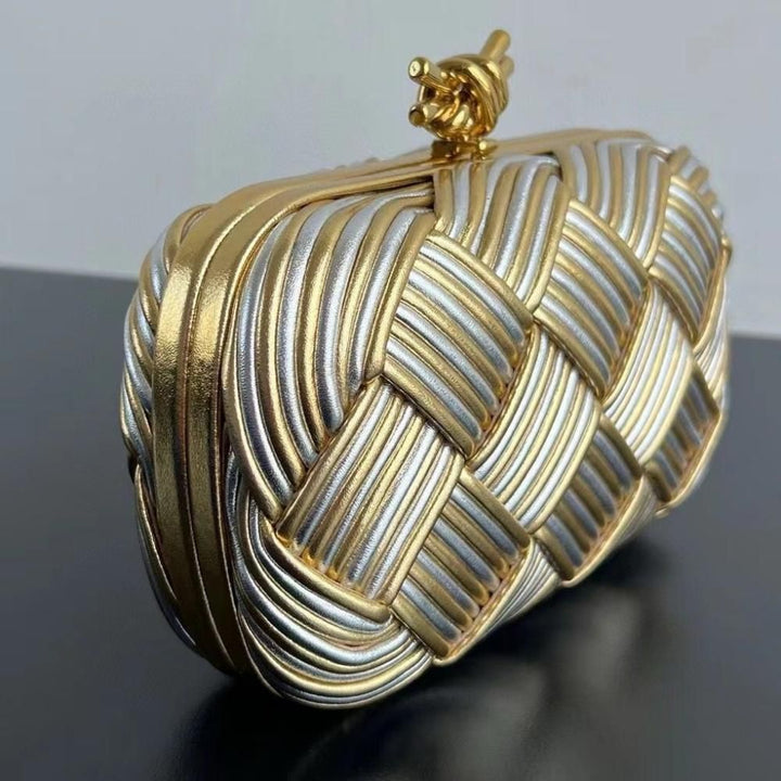 Gold-tone clasp closure close-up detail on black woven evening handbag


