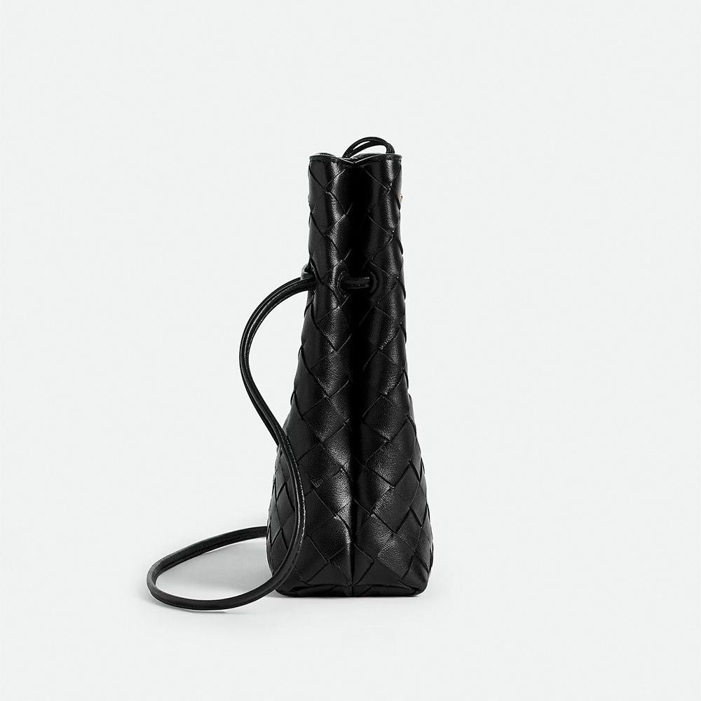 Black woven handbag on a light gray background