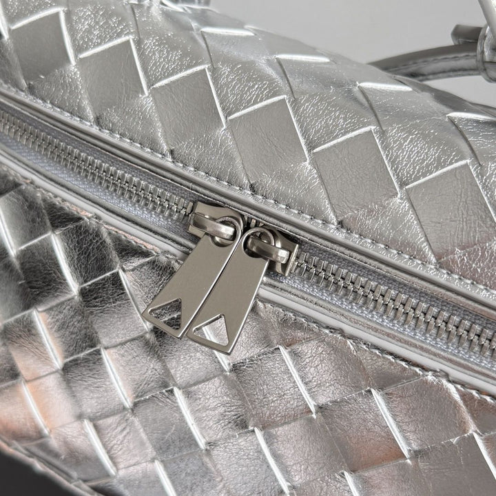 Silver woven leather vanity crossbody bag angle view showing adjustable strap and structured body