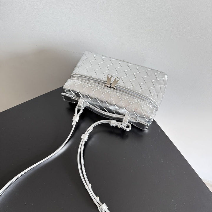 Metallic woven vanity bag side view showing structured rectangular silhouette and strap